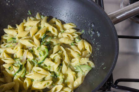 That has Zucchini pasta cook at home on a skillet over a gas stove.の写真素材