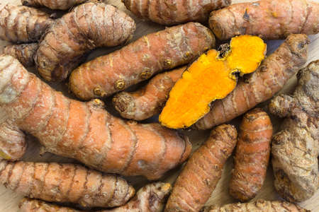 Fresh turmeric roots and one sliceの写真素材