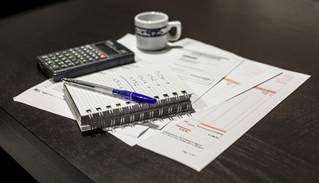 Calculation of the utility bills  Scene with pen, bills, calculator and coffeeの写真素材