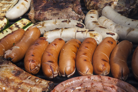 Barbecue with pork ribs, german sausages and courgetteの写真素材