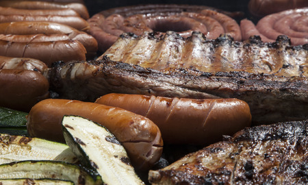 Barbecue with pork ribs, german sausages and courgette