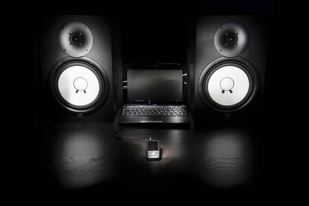 Composition  Mp3 player, laptop and speakers isolated on a black background