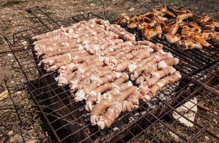 Big barbecue with raw sausage and chickenの写真素材