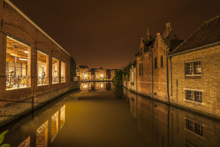 Romantic nocturnal view of a canal in Bruges. Buildings are reflected in the waterの写真素材