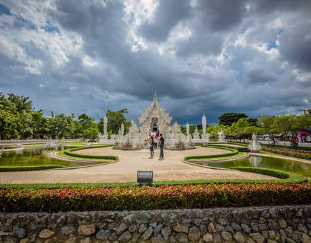 Chiang Rai (Thailand) - 10 June 2017: People are visiting the Wat Rong Khun, better known as the White Temple, a contemporary and unconventional Buddhist temple in Chiang Rai province during an overcast dayのeditorial素材