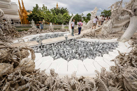 Chiang Rai (Thailand) - 10 June 2017: People are visiting the Wat Rong Khun, better known as the White Temple, a contemporary and unconventional Buddhist temple in Chiang Rai province during an overcast dayのeditorial素材