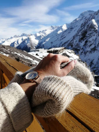 Hand holds a hat on a background of mountains, Elbrus