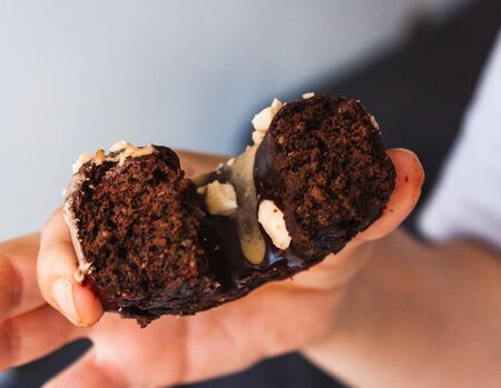 Hand holding a bitten donuts with white backgroundの写真素材