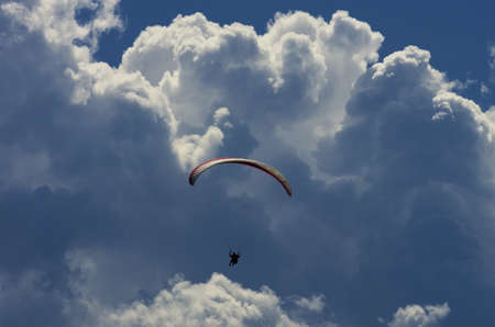 Paraglider with dramatic sky and huge cloudsの写真素材
