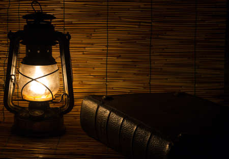 Set with an old rusty lantern and a bookの写真素材