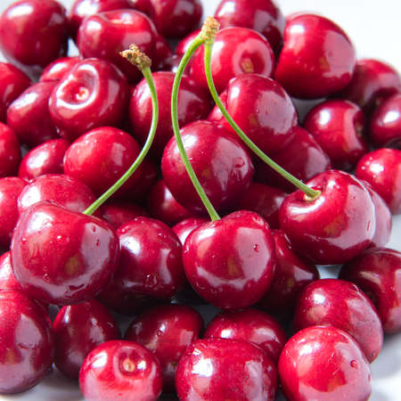Bowl of red fresh cerries on a white backgroundの写真素材