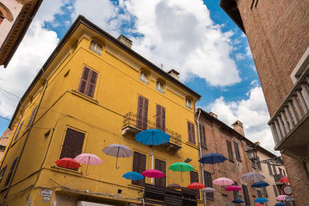 Ancient medieval street in the downtown of Ferrara city with umbrellasのeditorial素材