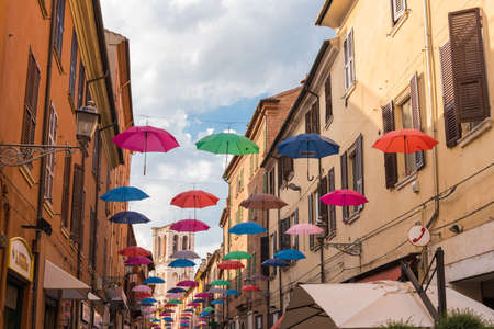 Ancient medieval street in the downtown of Ferrara city with umbrellasのeditorial素材