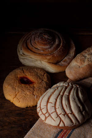 Vertical view of photograph of sweet bread on rustic canvas, setting the table in a cozy, dark...
