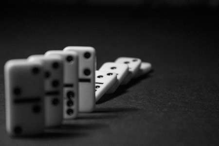 Dominoes on a black background. Black and white photo.