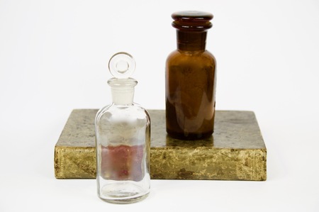 Book and antique glass jar isolated on white backgroundの写真素材
