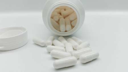 White capsules in the pharmacy laboratory isolated on white backgroundの写真素材