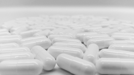 White capsules in the pharmacy laboratory isolated on white backgroundの写真素材