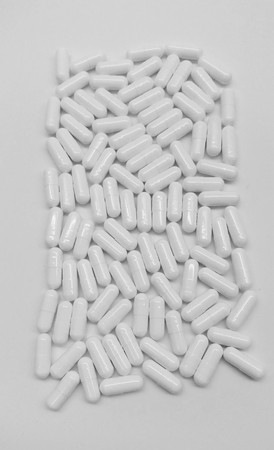 White capsules in the pharmacy laboratory isolated in white backgroundの写真素材