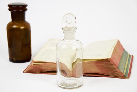 Book and antique glass jar isolated on white backgroundの写真素材