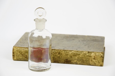 Book and antique glass jar isolated on white backgroundの写真素材