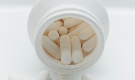 White capsules in the pharmacy laboratory isolated in white backgroundの写真素材