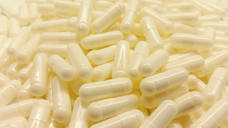 White capsules isolated in white backgroundの写真素材
