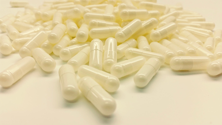 White capsules isolated in white backgroundの写真素材