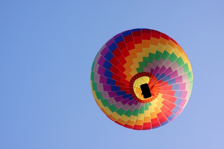 hot air balloon in a blue sky seen from below  