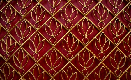 Golden curved steel door, lotus pattern, with red backgroundの写真素材