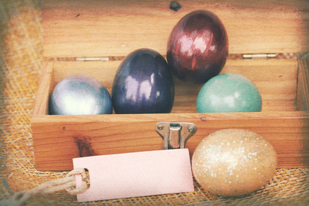 Vintage paper textures, Colorful easter egg in wood box with paper tag.の写真素材