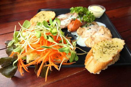 Grilled steaks, sausage, garlic bread and salad recipe.の写真素材