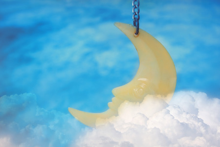 Mobile moon sleeping on white cloud with night sky background.の写真素材