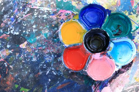 Dirty watercolor palette on dirty table.の写真素材