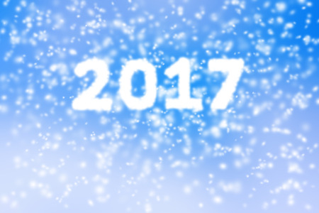 Happy new year 2017 background of blurred snow storm on blue sky.
