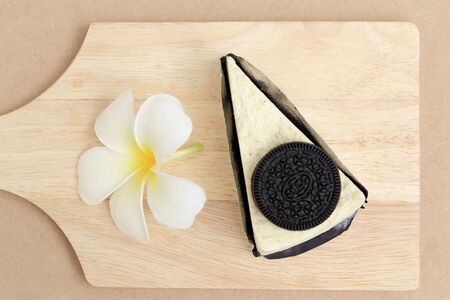 Pieces of Cookie  Cheesecake and white flower on wooden plate.
