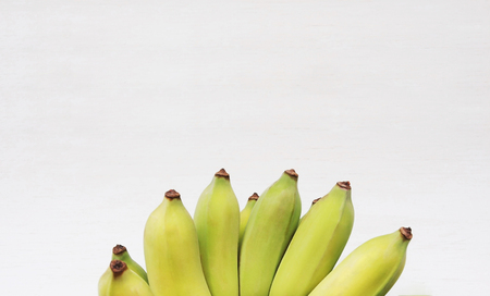 Bunch of Cultivated bananas or Thai bananas on white wooden with space for text.の写真素材