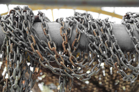 Pattern of thick rusty chain hang on iron rail.