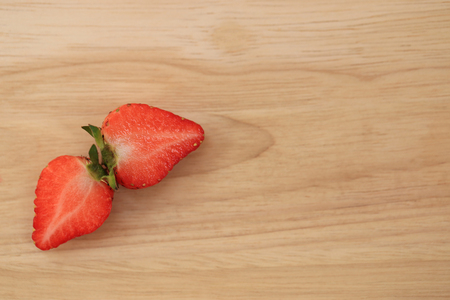 Cut fresh strawberries top view with space for text on wooden background.の写真素材