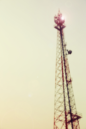 Vintage toned and blurred electricity power post tower on pale white sky background.の写真素材