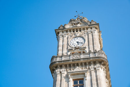 Dolmabahce Clock Tower an iconic historical landmark monument in Istanbul, Turkey. Ornate stone...