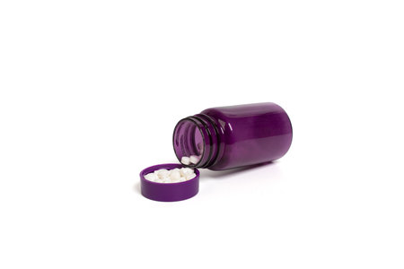 Purple pill bottle with white tablets on isolated white background. Close-up of medicine bottle and...