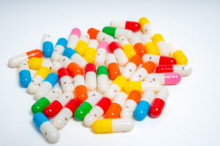 Scattered colorful medicine capsules on isolated white background, vibrant pill assortment. Close up of colorful pills spread out. Health, medication, wellness, treatment conceptの写真素材