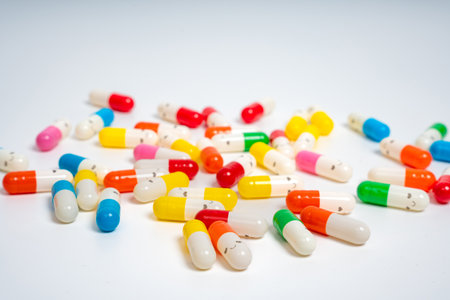 Scattered colorful medicine capsules on isolated white background, vibrant pill assortment. Close up of colorful pills spread out. Health, medication, wellness, treatment conceptの写真素材
