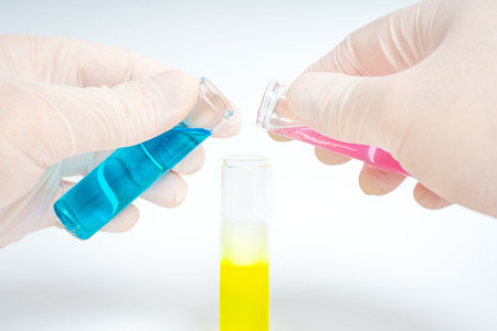 Laboratory test tubes with blue and yellow liquid on a white backgroundの写真素材