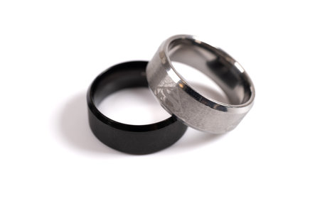 Two silver rings. White and black silver ring isolated on white background. Togetherness, wedding,...