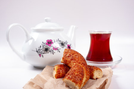 Turkish breakfast, sliced turkish bagel, cup of tea and teapot, isolated on white backgroundの写真素材