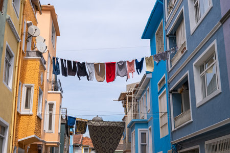 Colorful street in Balat with clothes hanging from line between two houses buildings. Washed clothes...