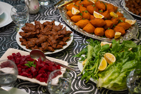 Plate of traditional kofte served with beet salad, greens and lemon slices. Traditional middle eastern and turkish cuisine kibbeh. Spicy bulgur meatballs. Table dinner conceptの写真素材