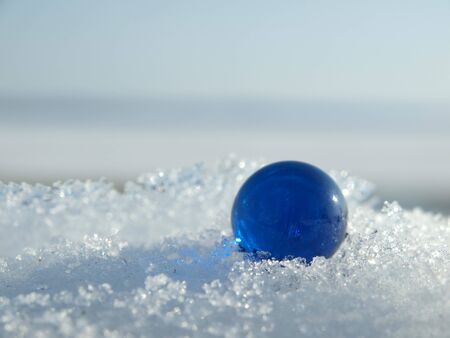 Blue ball on a snow in the winter     の写真素材